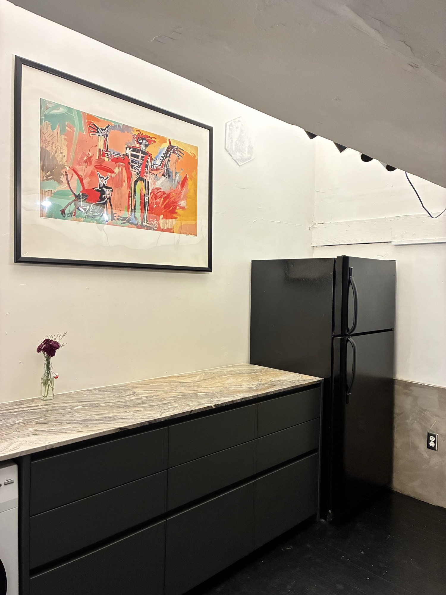 Finished kitchen with black cabinetry and marble counter